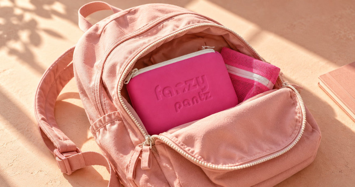 Pink backpack open with a pink Fanzy Pantz pouch and laundry bag packed inside