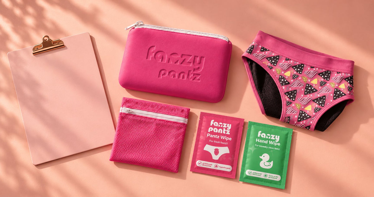 Fanzy Pantz pouch, undies, laundry bag and wipes laid out beside a pastel clipboard
