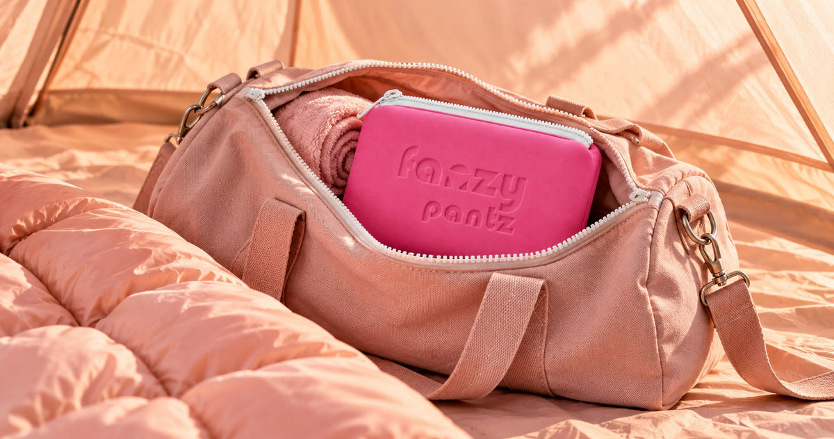 Pink duffel bag with a Fanzy Pantz pouch packed inside, in a tent
